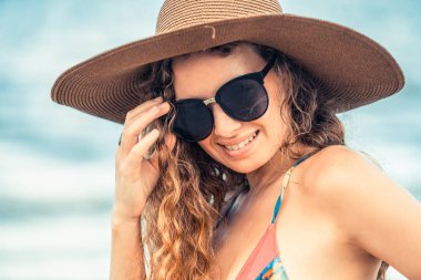Tatil seyahat etmek tatil için yaz aylarında tropikal plaj keyfi yerinde mayo giyen mutlu genç kadın.