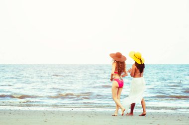 Bikinili mutlu kadın birlikte yaz tatil tropikal kum plaj güneşlenme gitmek. Seyahat yaşam tarzı.