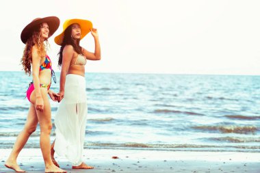 Bikinili mutlu kadın birlikte yaz tatil tropikal kum plaj güneşlenme gitmek. Seyahat yaşam tarzı.