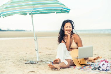 Artı boyutu yaz aylarında tropikal Kum Plajı üzerinde oturan bir genç bayan. Tatil seyahat etmek tatil.