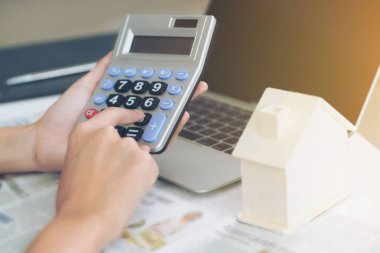 İşçisi kadın muhasebeci veya banka hesap makinesi ofiste ev kredi kredi bürokrasi hesaplamak için kullanır.
