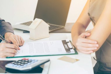 İstemci belge ile ilgili Emlak etkinlik avukat veya gerçek emlakçı ofis masa başında oturan yanındaki imzalar. Satış ve ev satın alma iş kavramı.