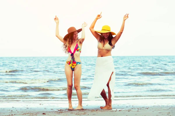Bikinili mutlu kadın birlikte yaz tatil tropikal Kum Plajı üzerinde dans. Seyahat yaşam tarzı.