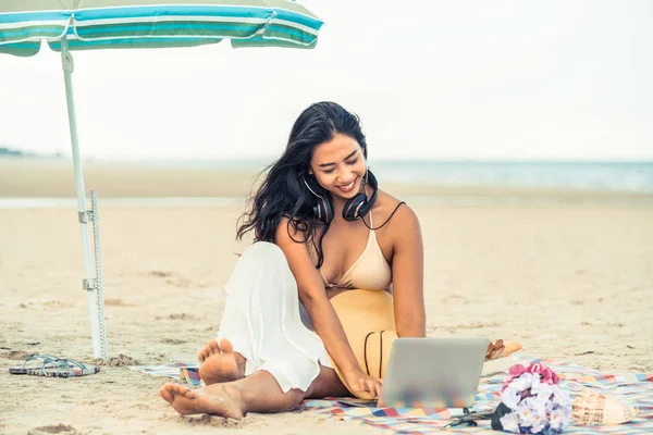 Artı boyutu yaz aylarında tropikal Kum Plajı üzerinde oturan bir genç bayan. Tatil seyahat etmek tatil.