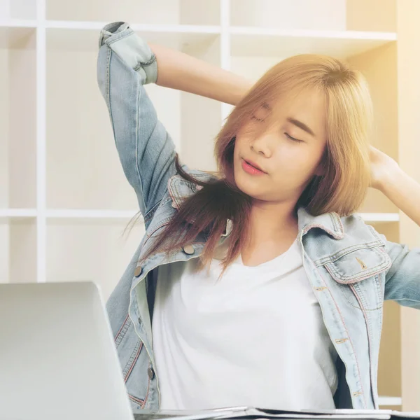 Çalışma ofisinde bittiğinde rahat genç kadın kol ve omuz kas uzanır. Memnun ve endişesiz iş iş kavramı.