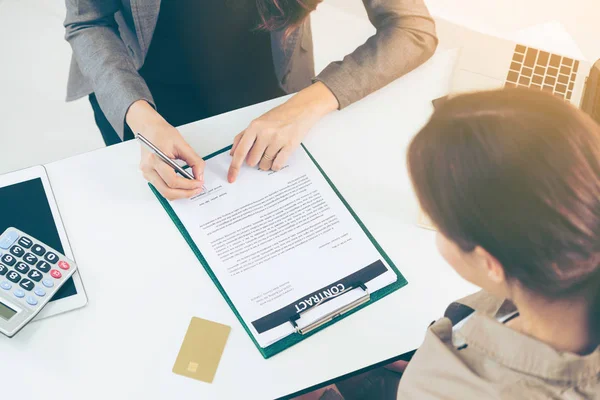 İşkadını işaretleri sözleşmesi sözleşme ile ofiste başka bir iş kadını. Kadının el ateş yakın. İş ortaklığı ve avukat yasal faaliyetleri kavramı.