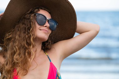 Tatil seyahat etmek tatil için yaz aylarında tropikal plaj keyfi yerinde mayo giyen mutlu genç kadın.