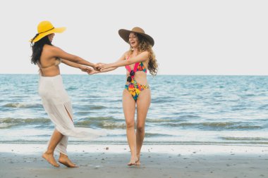 Bikinili mutlu kadın birlikte yaz tatil tropikal Kum Plajı üzerinde dans. Seyahat yaşam tarzı.