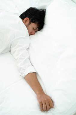 Beyaz keten yatak yatak odasında uykusunda genç adam.