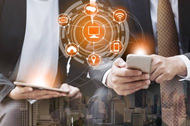 Cep telefonu ile modern şehir binaları arka plan kullanarak genç iş adamları. Gelecekteki telekomünikasyon teknolojisi ve internet şeyler (çok) kavramının.