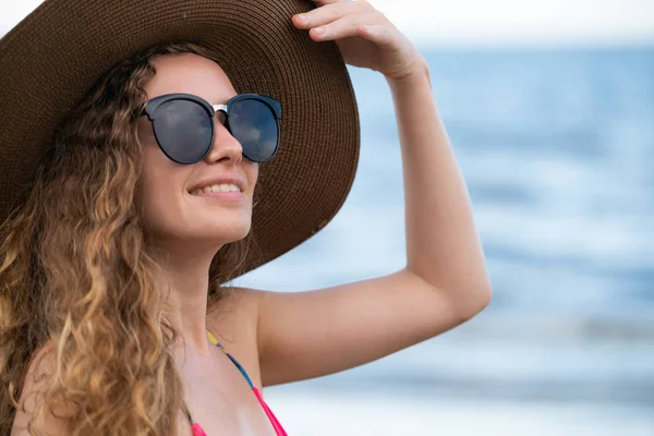 Tatil seyahat etmek tatil için yaz aylarında tropikal plaj keyfi yerinde mayo giyen mutlu genç kadın.