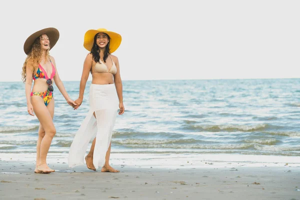 ビキニで幸せな女性は 夏休みで熱帯の砂浜に一緒に日光浴に行きます 旅行のライフ スタイル — ストック写真