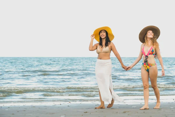 Bikinili mutlu kadın birlikte yaz tatil tropikal kum plaj güneşlenme gitmek. Seyahat yaşam tarzı.