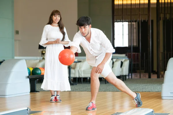 Young couple playing bowling at the club. Sport and recreation lifestyle.