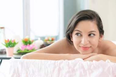 Lüks spa merkezinde masaj tedavisi için hazırlanan spa yatakta yalan rahat genç kadın. Sağlık, stres rahatlama ve gençleşme kavramı.