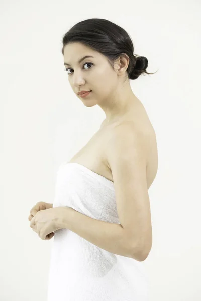 美丽的年轻妇女与干净的皮肤白色毛巾对白色背景 面部护理 美容和健康水疗 — 图库照片