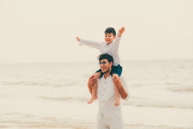 Mutlu baba oğlu yaz aylarında boyun tropikal bir kum Plajı üzerinde taşıyan.