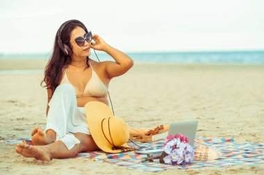 Artı boyutu yaz aylarında tropikal Kum Plajı üzerinde oturan bir genç bayan. Tatil seyahat etmek tatil.