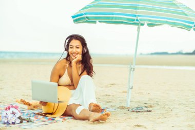 Artı boyutu yaz aylarında tropikal Kum Plajı üzerinde oturan bir genç bayan. Tatil seyahat etmek tatil.