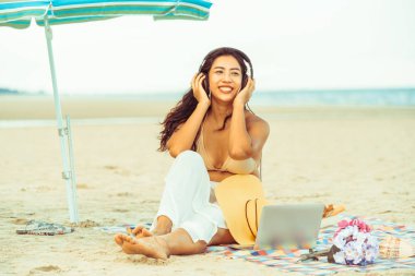 Artı boyutu yaz aylarında tropikal Kum Plajı üzerinde oturan bir genç bayan. Tatil seyahat etmek tatil.