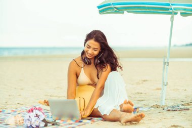 Artı boyutu yaz aylarında tropikal Kum Plajı üzerinde oturan bir genç bayan. Tatil seyahat etmek tatil.