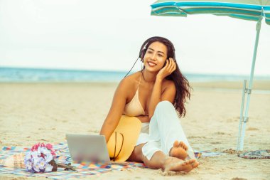 Artı boyutu yaz aylarında tropikal Kum Plajı üzerinde oturan bir genç bayan. Tatil seyahat etmek tatil.