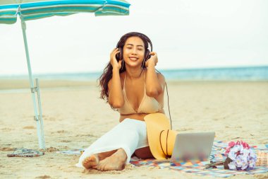 Artı boyutu yaz aylarında tropikal Kum Plajı üzerinde oturan bir genç bayan. Tatil seyahat etmek tatil.