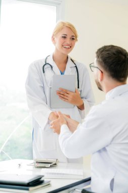 El sıkışma başarı ve profesyonel sağlık personeli ekip çalışması gösteren başka bir doktora veren hastanede doktor.