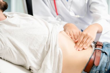Kadın doktor konuşuyor ve erkek hasta hastane ofisinde inceleyerek. Sağlık ve tıbbi hizmet.