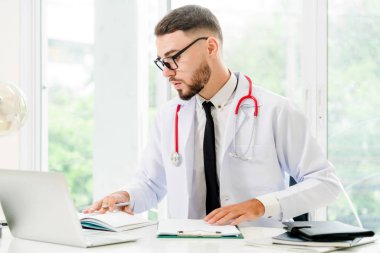 Doktor hastanede Ofis masaları, dizüstü bilgisayar üzerinde çalışıyor. Tıbbi ve sağlık kavramı.