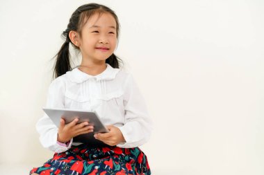 Tablet bilgisayar ile beyaz arka plan üzerinde küçük mutlu çocuk. Çocukluk yaşam tarzı.