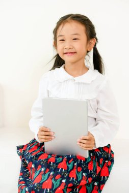 Tablet bilgisayar ile beyaz arka plan üzerinde küçük mutlu çocuk. Çocukluk yaşam tarzı.