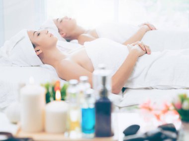 Spa yatağında uzanan rahat genç bir kadın lüks bir spa merkezinde yüz bakımı ve masaj için hazırlandı. Sağlık, stres atma ve gençleştirme kavramı.