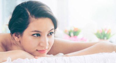 Lüks spa merkezinde masaj tedavisi için hazırlanan spa yatakta yalan rahat genç kadın. Sağlık, stres rahatlama ve gençleşme kavramı.