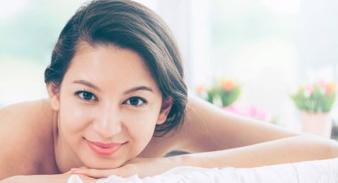 Lüks spa merkezinde masaj tedavisi için hazırlanan spa yatakta yalan rahat genç kadın. Sağlık, stres rahatlama ve gençleşme kavramı.