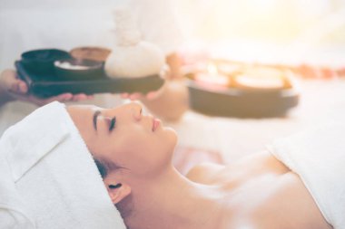 Rahat kadın kaplıca tedavisi planda tutan terapist ile spa masaj için hazırlanan spa yatakta yalan. Lüks sağlık, stres rahatlama ve gençleşme kavramı.