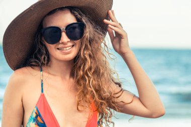 Tatil seyahat etmek tatil için yaz aylarında tropikal plaj keyfi yerinde mayo giyen mutlu genç kadın.