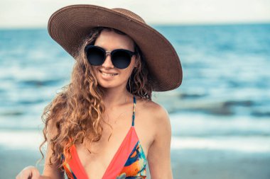 Tatil seyahat etmek tatil için yaz aylarında tropikal plaj keyfi yerinde mayo giyen mutlu genç kadın.