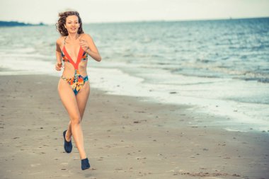 Çekici kadın runner yaz aylarında tropikal Kum Plajı üzerinde çalışır. Sağlıklı yaşam tarzı ve koşma spor kavramı.