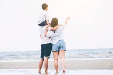 Baba, anne ve oğlu, mutlu aile tatil tropikal bir kum Plajı üzerinde yaz aylarında gider.