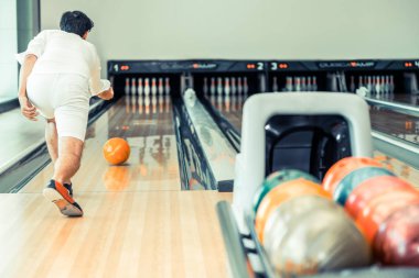 Genç adam bowling spor kulübünde oynarken.