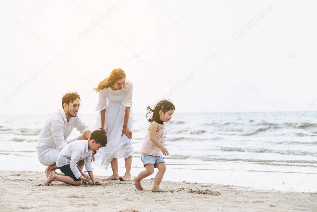 Happy family of father, mother and kids goes vacation on a tropical sand beach in summer.