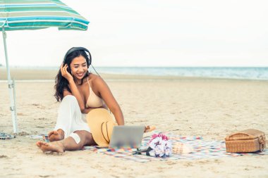 Artı boyutu yaz aylarında tropikal Kum Plajı üzerinde oturan bir genç bayan. Tatil seyahat etmek tatil.
