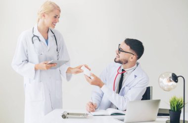 Doktor hasta başvuru hakkında tartışma yaparken başka bir doktora ilaç şişe geçirerek hastaneye ofisinde.