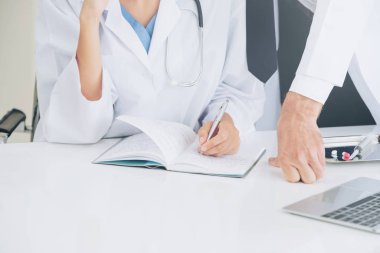 Doktor hastane ofis notlar hastalar raporda başka bir doktor ile konuşma yaparken o ayakta yanında yazıyor.