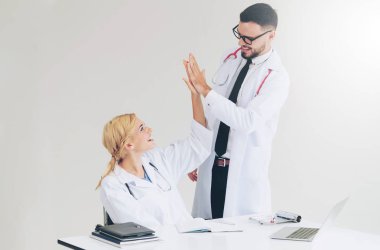 Mutlu başarılı doktor ile hasta tedavi başarısı için duran başka bir doktor hastane office zafer kutluyor.