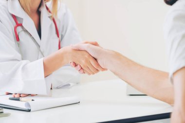 Kadın doktor hastane office odasında erkek hasta ile karşılıklı yapıyor. Sağlık ve Medikal hizmet meslekleri.