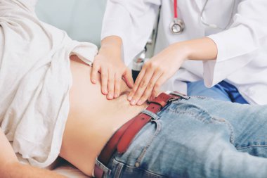 Kadın doktor konuşuyor ve erkek hasta hastane ofisinde inceleyerek. Sağlık ve tıbbi hizmet.