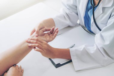 Kadın doktor hastane ofiste bayan hasta için eller tarafından hasta darbe incelenirken konuşuyor. Sağlık ve tıbbi hizmet.
