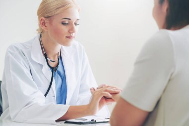 Kadın doktor hastane ofiste bayan hasta için eller tarafından hasta darbe incelenirken konuşuyor. Sağlık ve tıbbi hizmet.